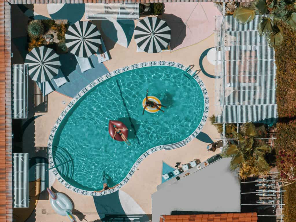 Colorful swimming pool with sun umbrellas and lounging area, perfect for outdoor relaxation.